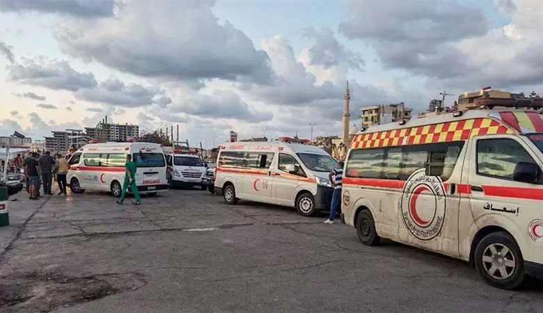سيارات إسعاف في ميناء طرطوس استعداداً لنقل الناجين الذين يتم انتشالهم من البحر إلى المستشفى